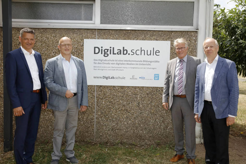 Senioren vor dem Schild 'Digilab: Schule für Digitalisierung